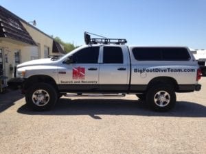 Silver work truck with decals for search and recovery company