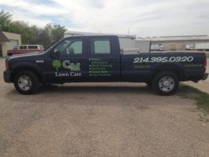 Blue work truck with decals for lawn care company