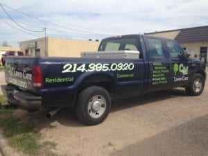 Back of blue work truck with decals for lawn care company