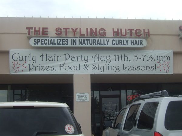 Hair salon with banner hanging that advertises a Curly Hair Party