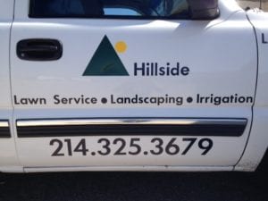 Side door of white truck with vinyl logo and lettering for lawn service company
