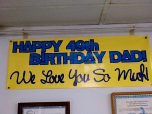 Yellow banner with blue lettering that says Happy 49th Birthday Day