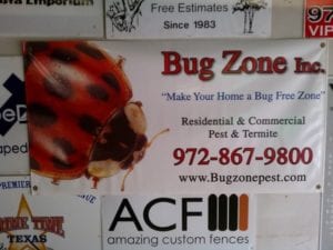White sign with large lady bug advertising a pest & termite company
