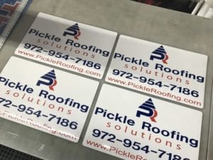 Set of 4 car magnets on a table for a roofing company