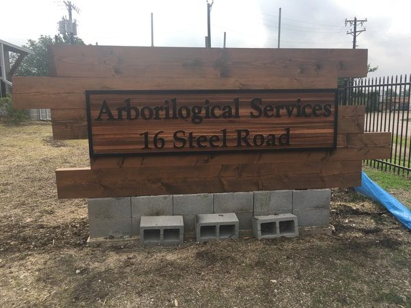 Cement and wooden sign for arborilogical services company