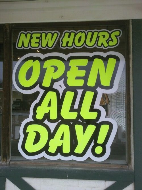 Bold neon window decals that says New Hours Open All Day