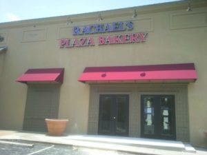Purple and pink storefront sign for Rachael's Plaza Bakery