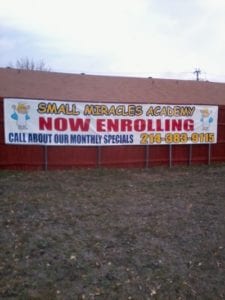 Large white banner on fence for children's academy