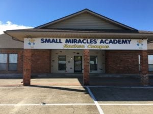 White outdoor banner for Small Miracles Academy