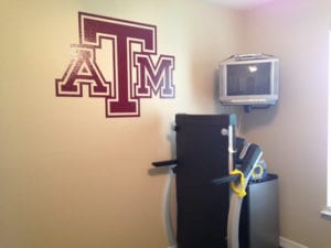 ATM university logos on wall in workout room
