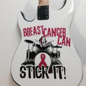 Backside of a guitar with vinyl decal of a woman drummer and the words breast cancer can stick it