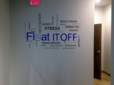 White wall in commercial building with decals of phrases such as float it off and brain fatique